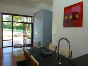 a kitchen with a sink and a table with chairs at Maison Campagne Petite Mère in Cabriès