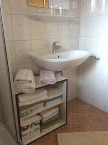 a bathroom with a sink and a bunch of towels at Apartment Gästehaus Wastian in Weissbriach