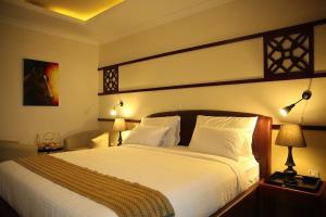 1 dormitorio con 1 cama blanca grande y 2 lámparas en Hotel Celeste Ethiopia, en Addis Ababa