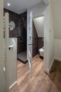 a bathroom with a shower and a toilet in it at Het Polderhuis in Den Burg
