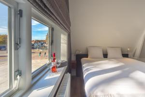 a bedroom with a bed and a window with a view at Het Polderhuis in Den Burg +20 photos
