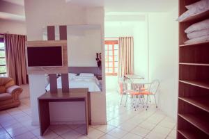 um quarto e uma sala de estar com uma cama e uma televisão em Termas Park Hotel em Gravatal