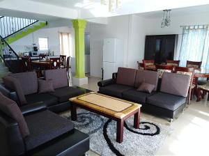 a living room with two couches and a coffee table at Green Discovery B&B Tamarind Falls 7 Cascades in Henrietta