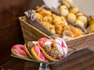 a plate of donuts on a table with two baskets of donuts at Residenza Favaro in Venice