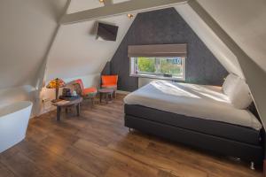 a bedroom with a large bed and a window at Het Polderhuis in Den Burg
