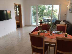 a living room with a table and chairs and a television at Apartmani Marija Klimno A in Klimno