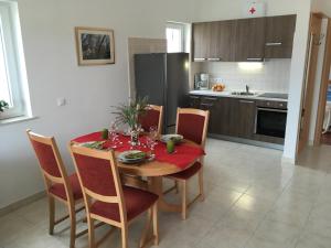 a kitchen with a table and chairs and a kitchen with a refrigerator at Apartmani Marija Klimno A in Klimno +16 photos