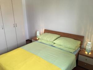 a bedroom with a bed with yellow and green sheets at Apartmani Marija Klimno A in Klimno