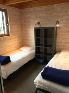two twin beds in a room with wooden walls at Villa Penfret - 50 meters from the beach in Île-Tudy