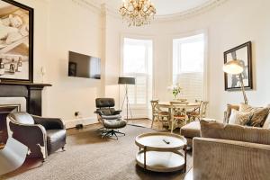 ein Wohnzimmer mit einem Sofa und einem Tisch in der Unterkunft JOIVY Luxury 2 and 3 bed flats on Historic George Street in Edinburgh