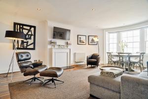 a living room with a couch and chairs and a table at ALTIDO Luxury 2 and 3 bed flats on Historic George Street in Edinburgh