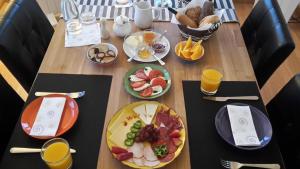 a wooden table topped with plates of breakfast food at Chalet Trolio bed & breakfast in Alhendín