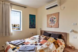 ein Schlafzimmer mit einem Bett mit einer Decke darauf in der Unterkunft Into Jerusalem heart in Jerusalem