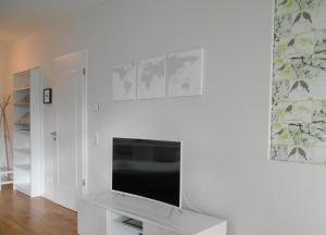 a living room with a flat screen tv on a white wall at Design Apartments - "Am Schlosspark" Adults Only in Potsdam