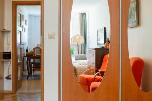 two views of a living room with an orange chair at Traditional Apartment Starowiślna street in Krakow