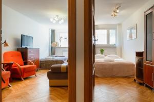 a bedroom with a bed and a living room at Traditional Apartment Starowiślna street in Krakow