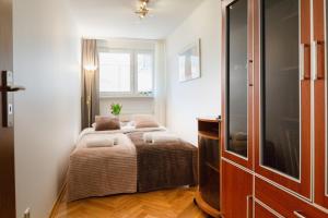a small bedroom with two beds and a window at Traditional Apartment Starowiślna street in Krakow