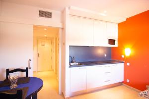 a kitchen with white cabinets and a table in a room at Apartamento Racimo El Puerto de Santa Maria in El Puerto de Santa María