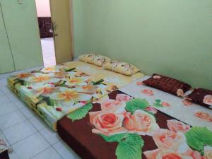 a bed with flowers on it in a room at Setro Kariyo Homestay in Bantul