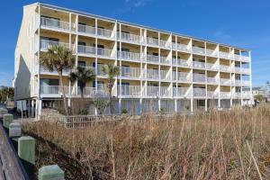 a large building with palm trees in front of it at Windy Shores II in Myrtle Beach