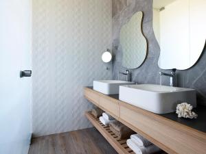 a bathroom with two sinks and a mirror at Youphoria Beach Front Villas in Korfalónas