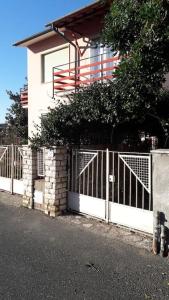 a white fence in front of a house at Casa Zelia in Castiglioncello