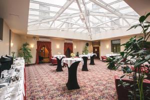a banquet hall with tables and chairs and plants at Monika Centrum Hotels in Rīga