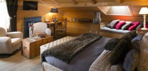 a living room with a large bed and a couch at Chalet-Hôtel Les Cimes in Le Grand-Bornand