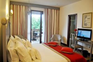 a bedroom with a bed and a desk and a television at Casa de St. Antônio Hotel Boutique in Parnaíba