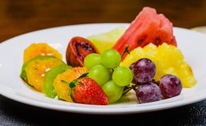 un plato blanco de fruta en una mesa en Alba Hotel Meru en Meru