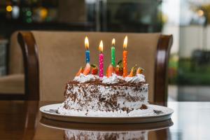 tort urodzinowy ze świecami na stole w obiekcie Alba Hotel Meru w mieście Meru