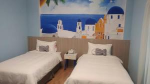 deux lits dans une chambre avec un tableau au mur dans l'établissement 蘑菇村一津宿囍民宿, à Taïtung