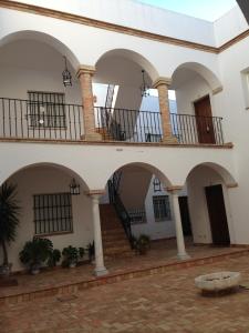 a courtyard with arches and stairs in a building at Quartos City Apartments Carmona in Carmona