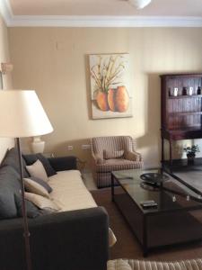 a living room with a couch and a table at Quartos City Apartments Carmona in Carmona