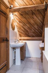 a bathroom with a sink and a wooden ceiling at Cottage 2 New Yatt Farm in Witney