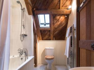 a bathroom with a toilet and a tub and a sink at Cottage 2 New Yatt Farm in Witney