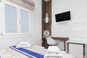 a bedroom with a bed and a desk and a tv at Villa Ilias in Firostefani