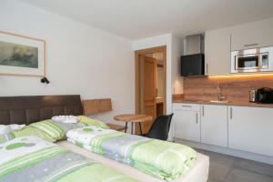 a bedroom with a bed and a small kitchen at Stadlchalet in Ried im Oberinntal