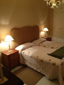 a bedroom with a bed and two night stands with lamps at Quartos City Apartments Carmona in Carmona