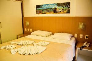 Una habitación de hotel con una cama con toallas. en Flat Pipa's Ocean a passos da Praia e centro Pipa, en Pipa