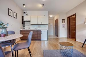 kuchnia i jadalnia ze stołem i krzesłami w obiekcie Trendy Apartment Kochanowskiego Street w Krakowie