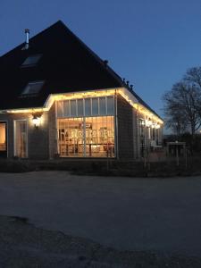 een huis met lichten aan de zijkant 's nachts bij Boerderij de Waard in Anna Paulowna