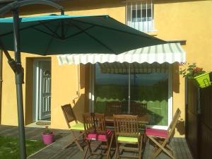 a table and chairs under an umbrella on a patio at GITE LA CLE DES CHAMPS in Chabeuil