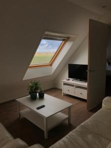 sala de estar con ventana, sofá y mesa en Boerderij de Waard, en Anna Paulowna