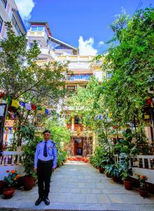 a man standing in a courtyard in front of a building at Kathmandu Boutique Hotel in Kathmandu