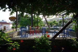 a group of blue chairs and tables in a garden at Vagia Traditional, Aegina Island in Vaia