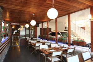 un restaurante con mesas y sillas de madera y un coche en Albatros Hotel, en Bodrum City