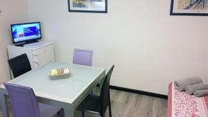 una camera con tavolo, sedie e televisore di Studio CENTRAL 3 - CIR 0402 ad Aosta