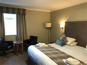 um quarto de hotel com uma cama e duas cadeiras em King Robert Hotel em Stirling