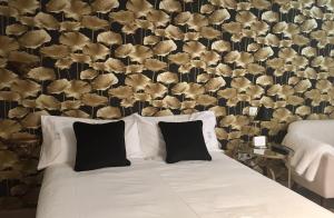a bed with black and white pillows in a bedroom at Puerta Trujillo in Plasencia +43 photos